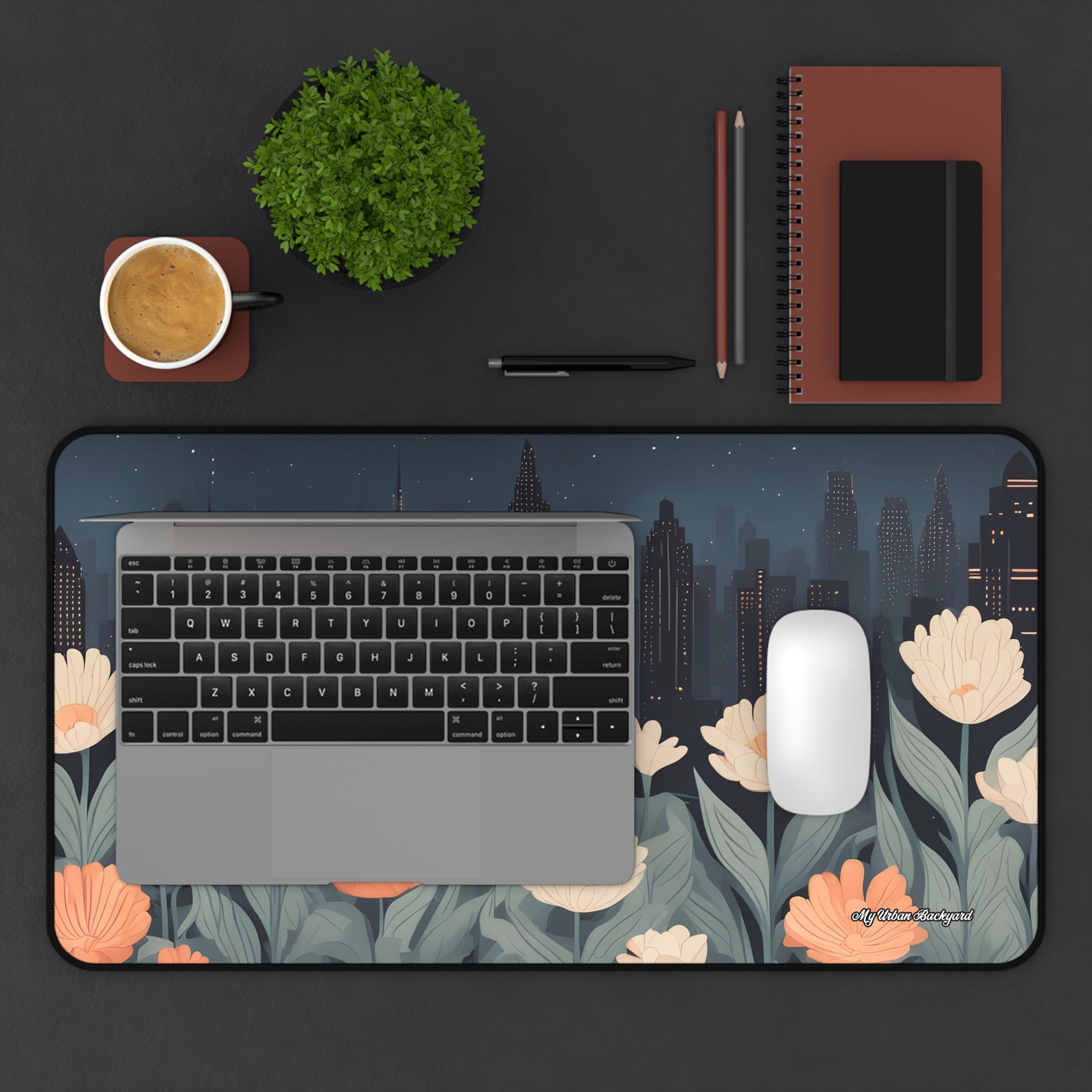 Floral desk mat with laptop, mouse, and office items on a dark surface