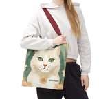 Person holding a tote bag with a cat design on a white background