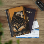 Notebook with bear design, passport, and airplane tickets on a wooden surface