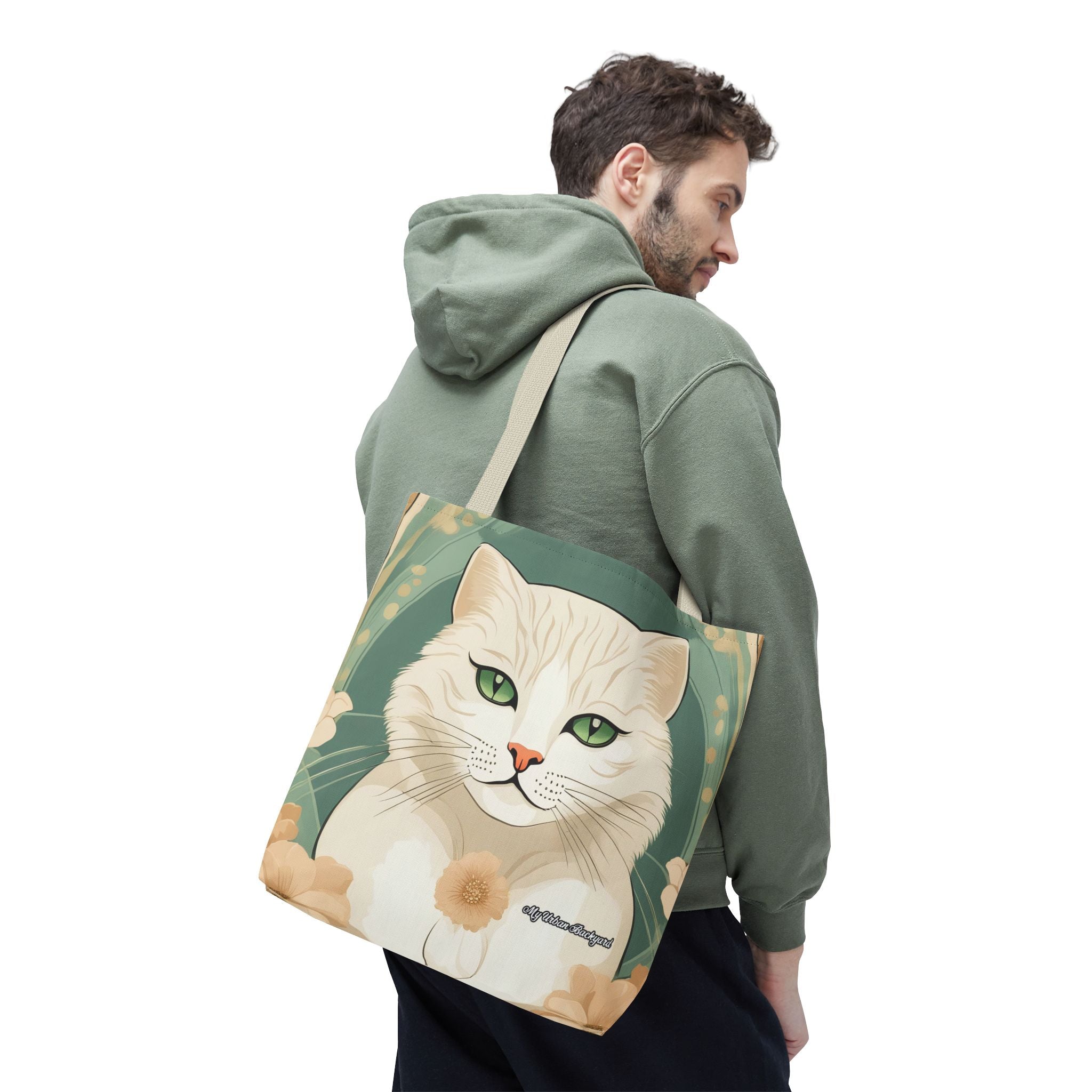 Man wearing a green hoodie with a tote bag featuring a cat design on his back